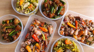 Yemek şirketi fikri, aşçı Asya mutfağı menüsü için yemek siparişi hazırlıyor.