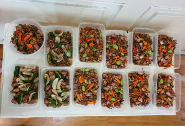 Yemek şirketi fikri, aşçı Asya mutfağı menüsü için yemek siparişi hazırlıyor.