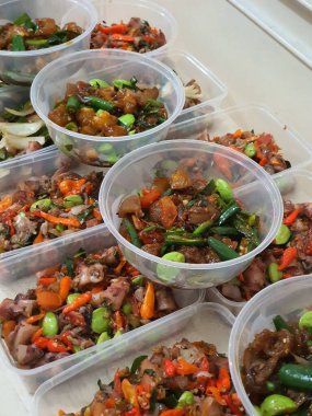 Yemek şirketi fikri, aşçı Asya mutfağı menüsü için yemek siparişi hazırlıyor.