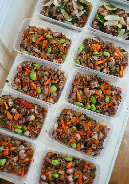 Yemek şirketi fikri, aşçı Asya mutfağı menüsü için yemek siparişi hazırlıyor.