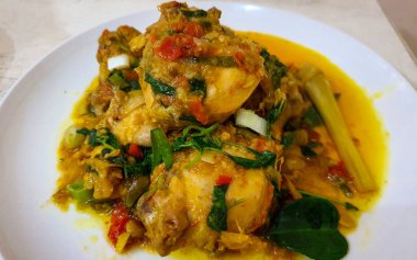 Ayam woku is a traditional dish from the Minahasa or Manado region of Indonesia, made of a chicken cooked mix of herbs and spices, ingredients are lemongrass, turmeric, kaffir lime leaves, and chili pepper home made cooking clipart