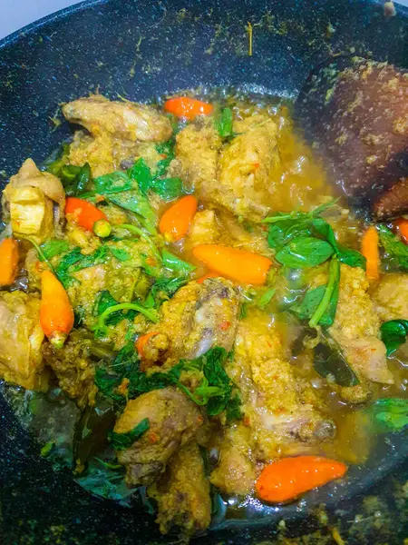 stock image Ayam woku is a traditional dish from the Minahasa or Manado region of Indonesia, made of a chicken cooked mix of herbs and spices, ingredients are lemongrass, turmeric, kaffir lime leaves, and chili pepper home made cooking