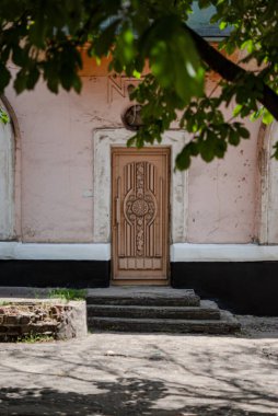 Yeşil sarmaşık ve ahşap kapılı eski taş ev..