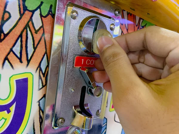 stock image Chance and Entertainment: Hand Inserting a Coin into a Game of Luck Machine