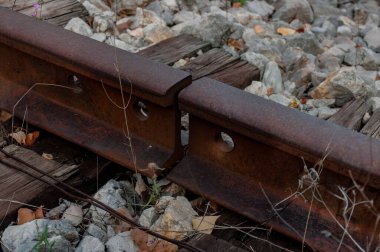 Sonbahar eski demiryolu. Delikli raylar, eski ahşap uykucular, renkli taşlar, paslı metal, nesne dokusu, tel..