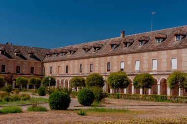 İspanya. Aranjuez. Kraliyet Sarayı 'nın çarşısı. Pencereli çatısı var. Yeşil çimenler. Royal Palace 'ın yanına park et. Taho Nehri. Sarayın yakınındaki kanal. Kanalın üzerindeki köprü. Mavi gökyüzü, beyaz bulutlar.