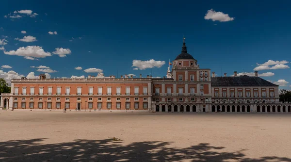 İspanya. Aranjuez. Kraliyet Sarayı 'nın çarşısı. Pencereli çatısı var. Yeşil çimenler. Royal Palace 'ın yanına park et. Taho Nehri. Sarayın yakınındaki kanal. Kanalın üzerindeki köprü. Mavi gökyüzü, beyaz bulutlar.