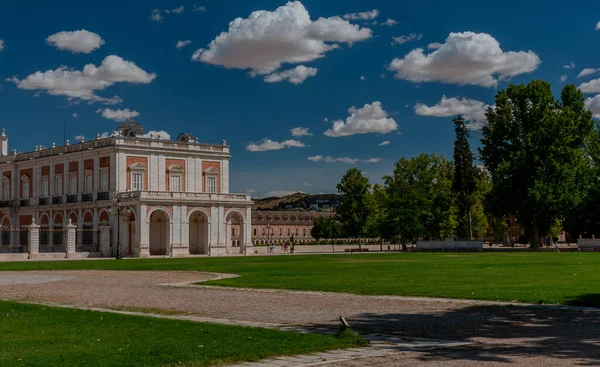 İspanya. Aranjuez. Kraliyet Sarayı 'nın çarşısı. Pencereli çatısı var. Yeşil çimenler. Royal Palace 'ın yanına park et. Taho Nehri. Sarayın yakınındaki kanal. Kanalın üzerindeki köprü. Mavi gökyüzü, beyaz bulutlar.