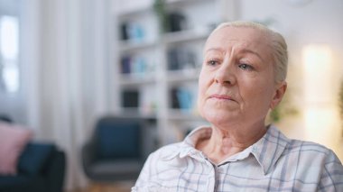Kıdemli kadın oturma odasında tek başına oturuyor. Kilitlenme, karantina ve sosyal uzaklık sorunlarıyla boğuşuyor.