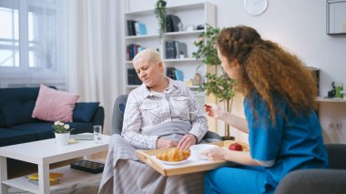 Hemşire tarafından hazırlanan öğle yemeğini yemeyi reddeden yaşlı kadın depresyondan muzdarip.