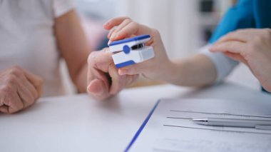 Terapist hastanın oksijen doygunluğunu ölçüyor. Kan seviyesi, elleri yakın çekim.