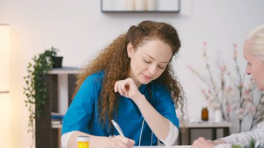Terapist olgun bir kadına danışıyor ve sağlık hakkındaki sorularını cevaplıyor.
