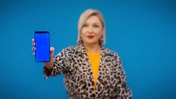 stock image A smartphone with a pre-keyed screen is being held by a mature woman, discounts and sales, mobile banking