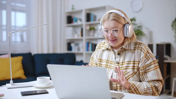 50多岁的快乐女人一边在笔记本电脑上看有趣的视频 一边休息和娱乐 — 图库照片