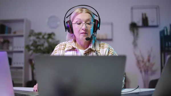 Skoncentrowana Starsza Kobieta Zestawie Słuchawkowym Grająca Grę Wideo Laptopie Zabawne — Zdjęcie stockowe