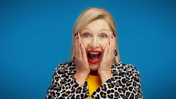 50 'li yaşlarda heyecanlı bir kadın büyük bir indirime ya da satışa tepki olarak şok olmuş bir ifade takınıyor.