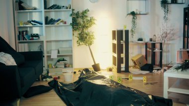 Yerde yatan bir cesedin bulunduğu plastik bir çantayla dağılmış bir dairedeki suç mahalli görüntüsü.