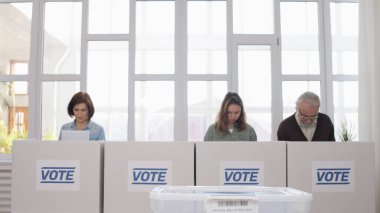 Oy verme yerinde duran insanlar oy pusulalarını okurken seçimler yapıyorlar, sorumlu vatandaşlar