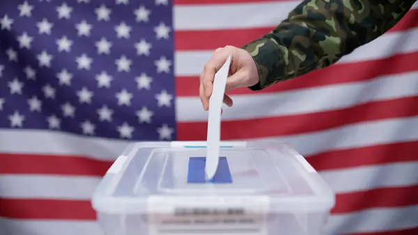 An American soldier throwing a voting ballot into the sealed box during the U.S. elections