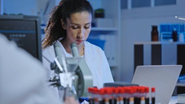 Bilgisayarda biyolojik çalışmanın sonuçlarını yazan kadın bilim adamı, araştırma yapıyor.