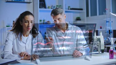 Modern laboratuvar ekipmanları kullanarak yeni virüsün yapısını tartışan iki bilim adamı