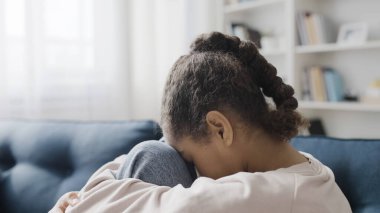 Diz çöküp ağlayan, yalnızlık çeken liseli kız çok üzgün.