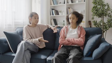 Üzgün siyah kız evde kadın arkadaşıyla konuşuyor, problemi tartışıyor, destek oluyor.