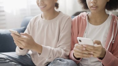 Afrikalı Amerikalı kız kardeşler akıllı telefonlar ve gençler üzerinde sosyal ağ uygulaması kullanıyorlar.