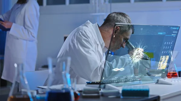 Virology lab worker examining samples under microscope, epidemic prevention