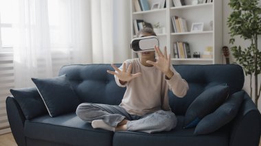 VR gözlüklü heyecanlı genç elleriyle uzaya dokunuyor, simülasyon oyunu oynuyor, artırılmış gerçeklik oynuyor.