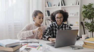 Afrikalı Amerikalı genç, en iyi arkadaşının online ödevini yapmasına yardım ediyor.