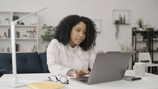 Attractive black woman works on her laptop, keeping up with business correspondence