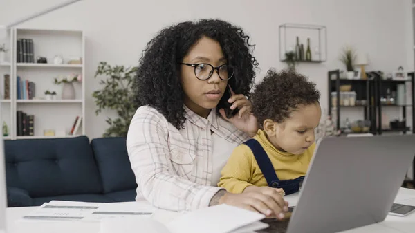 Young black mother works from home and takes care of her baby, earning extra income