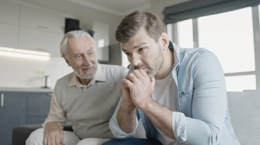 Büyük baba üzgün yetişkin oğlunu destekliyor, güvenilir aile ilişkisi.