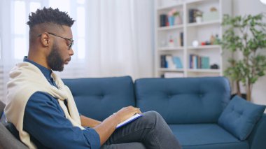 Yoğunlaşmış Afrikalı Amerikalı erkek psikolog ofisinde bir hasta bekliyor.