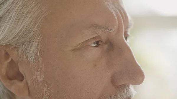 Close-up of eyes of confused senior man looking around, memory problems at old age