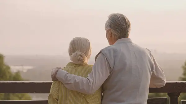 Mutlu son sınıf çifti birlikte gün batımının keyfini çıkarıyorlar, sevgili koca karısına sarılıyor.