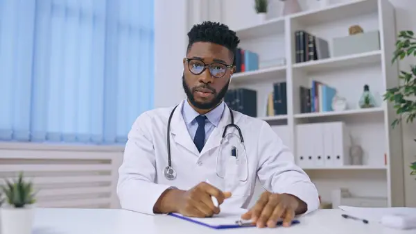 Friendly African American doctor consulting patient online, medical help, pov