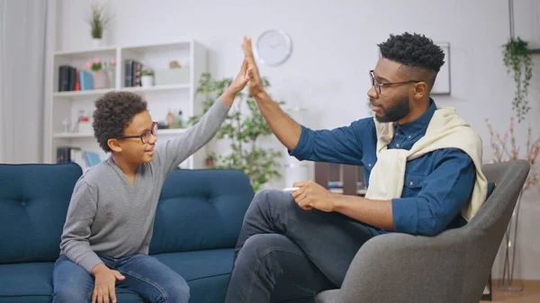 一个非洲裔美国心理学家和一个快乐的男孩在成功的治疗后给了对方5分 图库图片