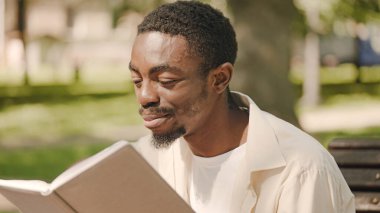 İlgilenen baba ebeveynlik hakkında kitap okuyor, bebek arabasının yanında oturuyor, doğum yapıyor.