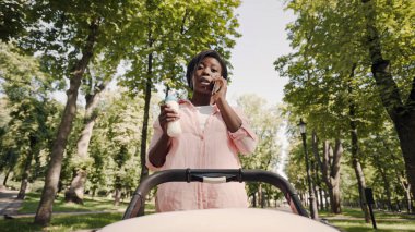 Endişeli anne bebek için süt formülü tutuyor, telefonla konuşuyor, bebeğin bakış açısı...