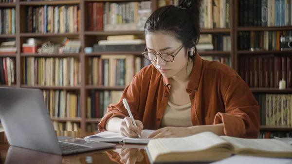 Kütüphanede ders çalışan yorgun genç bir kadın, yoğun bir iş yükü, akademik baskı...