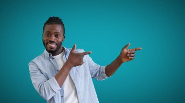 Neşeli adam işaret parmağını sola doğru gösteriyor, reklam sunuyor, satış yapıyor.
