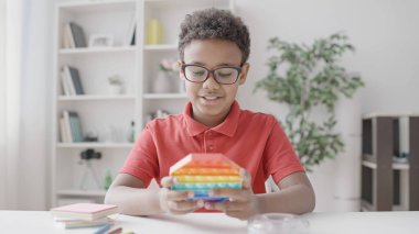 Okul çocuğu pop-it oynuyor, eğleniyor, çocuğun ilgisi, zihinsel mola