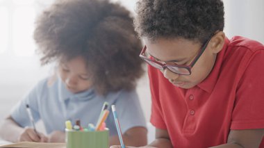 İlköğretim ve ilkokuldaki dersler sırasında öğrencilerin yazdıkları ödevlerle meşgul.