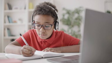 Çevrimiçi derste, okul sırasında Afrikalı Amerikalı çocukların yazı alıştırmaları.