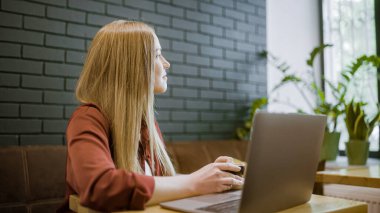 Kahve molasının tadını çıkaran mutlu kadın serbest yazar, masada dizüstü bilgisayar, ilham