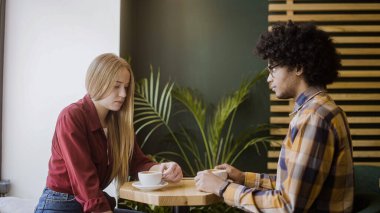 Kafede ayrılan bir çift, sevgilisinin üzgün kız arkadaşına bakması, ilişki krizi