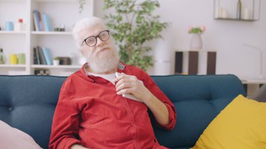 A thoughtful senior man  holding a photo frame, feeling the pang of loneliness and nostalgia