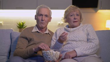 Kıdemli bir koca ve karısı birlikte korku filmi izlerken korkuyorlar.